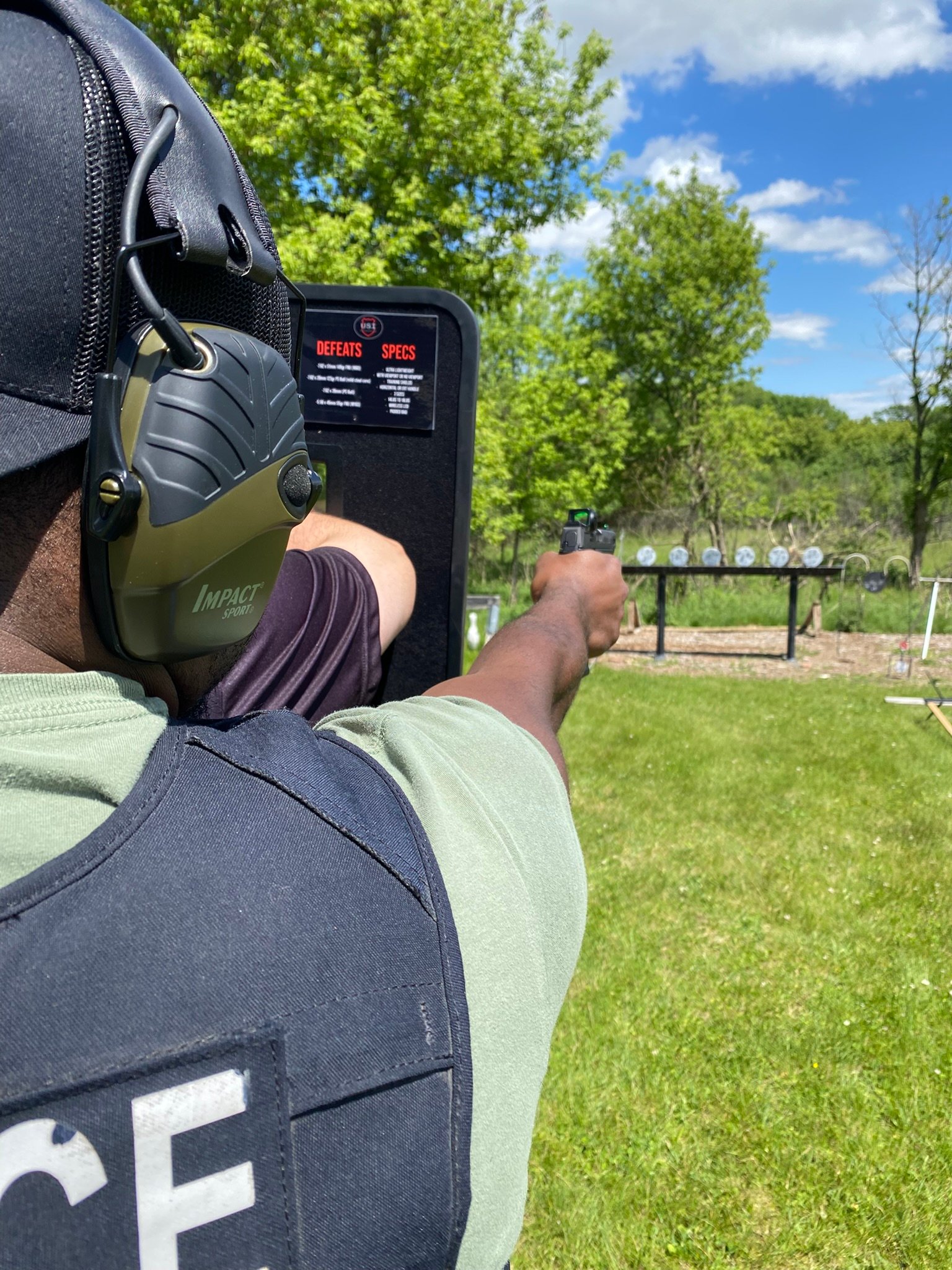 Officer with ballistic shield and pistol — outdoor range